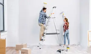 Para odnawia mieszkanie za remont, malując ściany na biało.