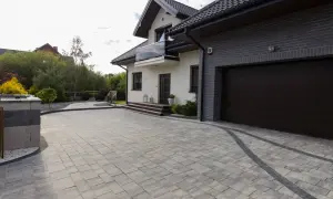 Nowoczesny dom z podjazdem z kostki brukowej. Różne rodzaje kostki brukowej tworzą estetyczny wzór.