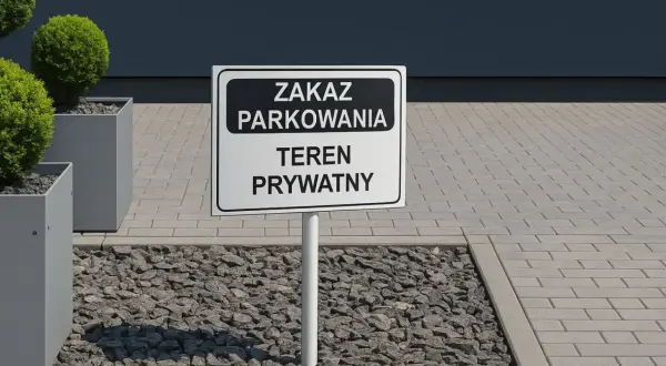Znak "Zakaz parkowania - teren prywatny" na tle nowoczesnego budynku i zieleni.