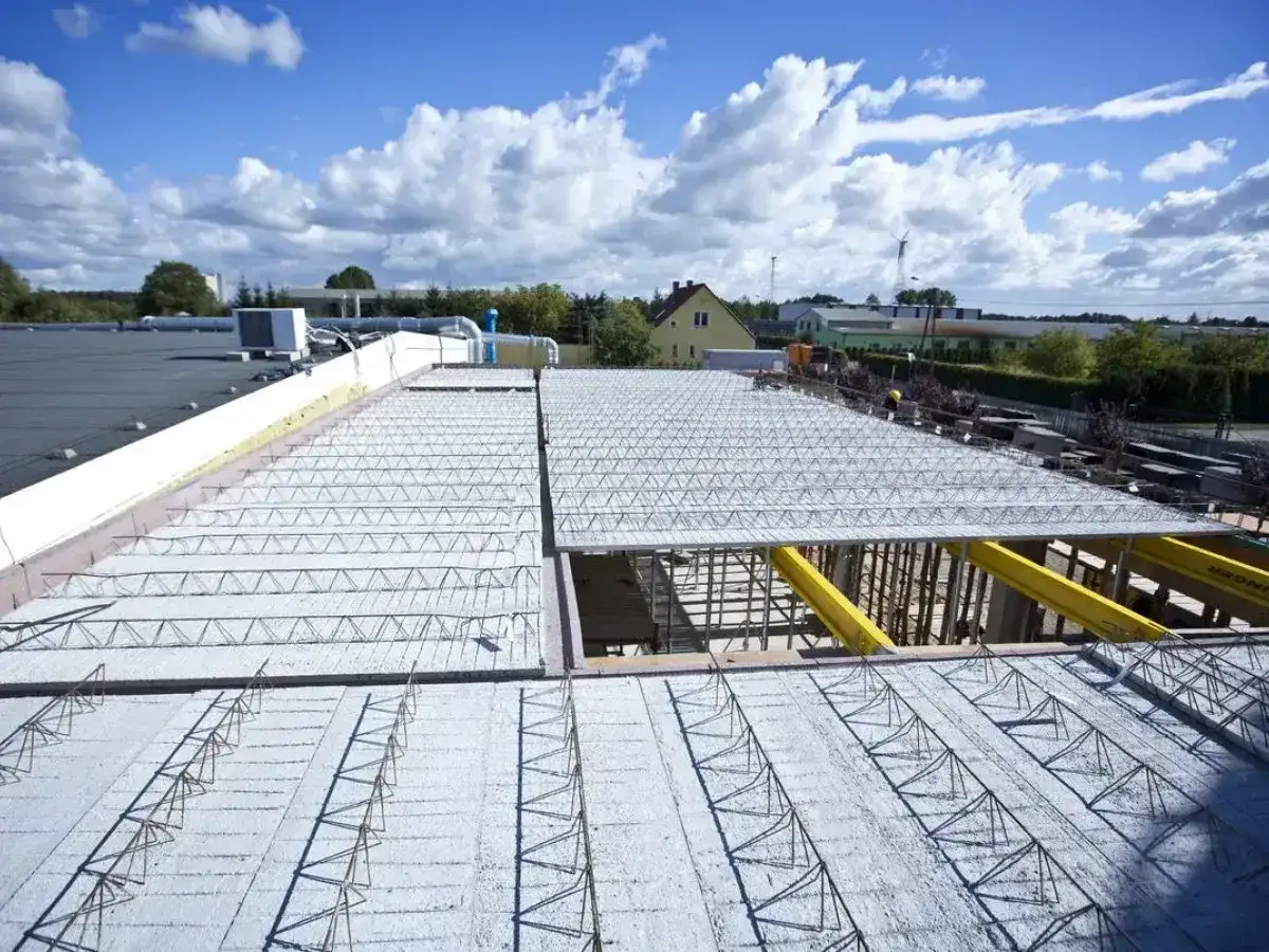 Budowa dachu z prefabrykowanych elementów, ukazująca różne rodzaje stropów w trakcie montażu.