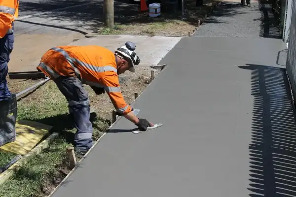 Robotnik wygładza świeży beton. Zastanawiasz się, jaka jest kubik betonu cena?